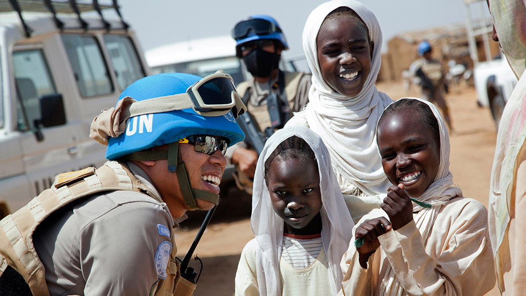UNAMID peacekeeper Lieutenant Colonel Yenni Windarti, of the Indonesia's civilian police, interacts with women and children at a water point in Abu Shouk camp for Internally Displaced Persons (North Darfur) during a morning patrol. UN Photo/Albert Gonzlez Farran