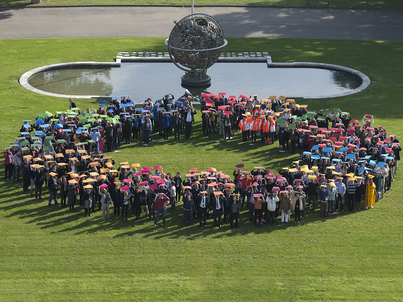 UN staff form a circle with the SDG colours