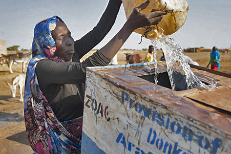 A woman pouring water into a container