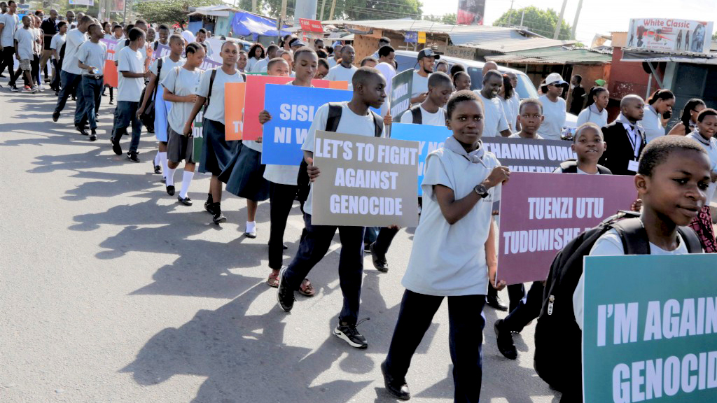 People march holding signs protesting against genocide