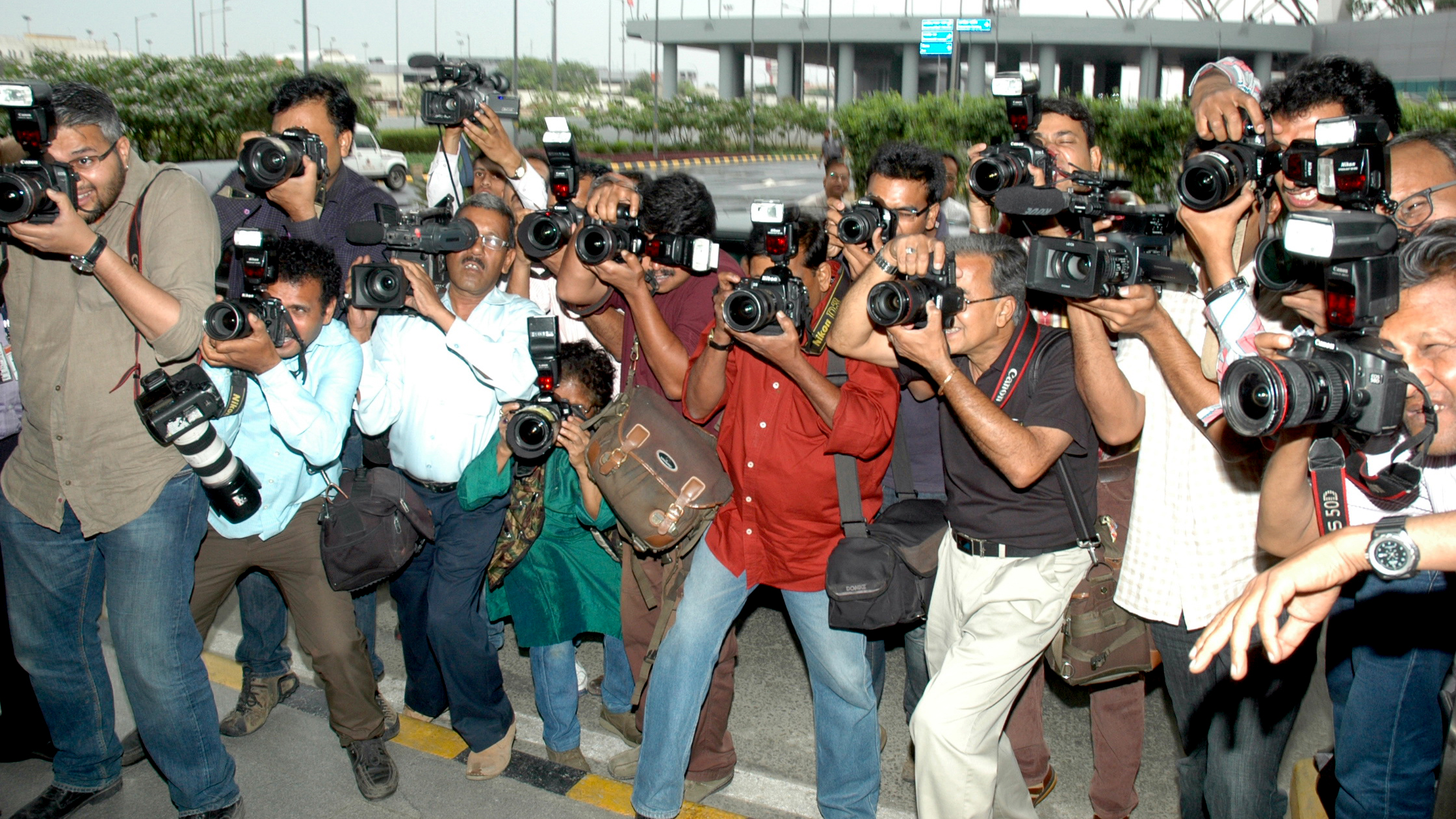 A group of people pointing professional cameras at the camera