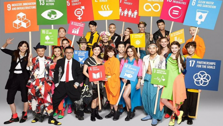 Artistas japoneses sostienen pancartas de los Objetivos de Desarrollo Sostenible