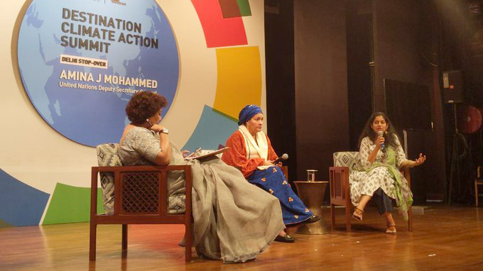 Three women sit on a stage with two other women.
