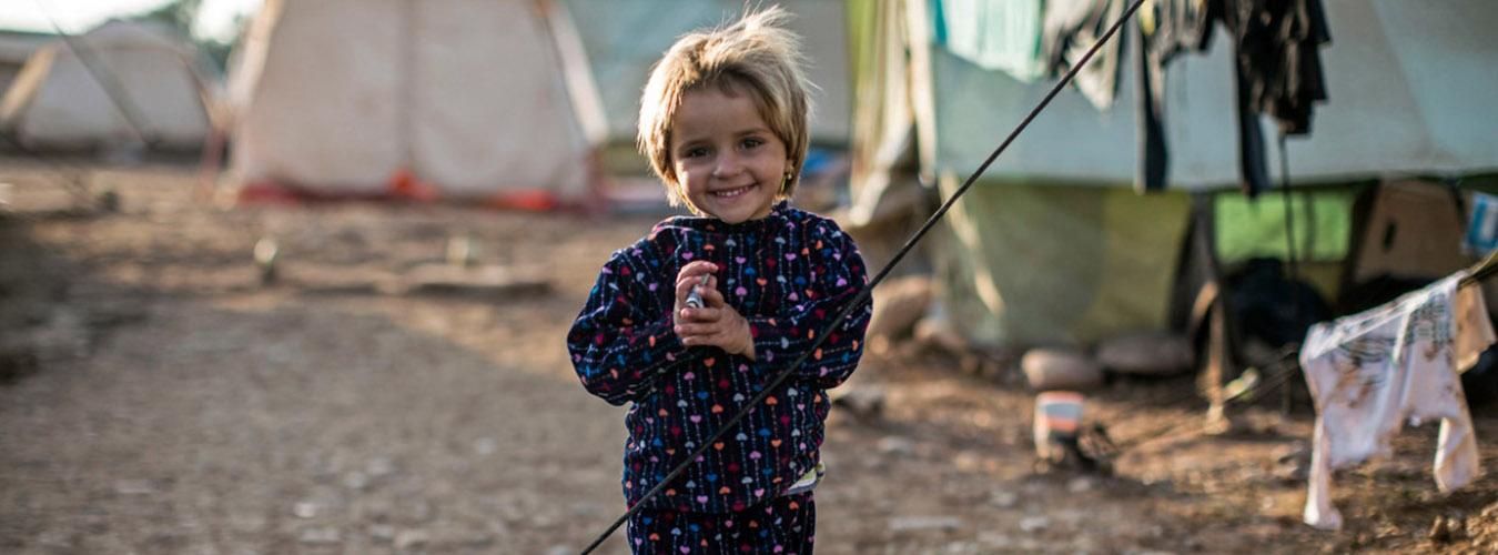 Una ni?a de pie cerca de las tiendas de campa?a en un campo de refugiados en Iraq.